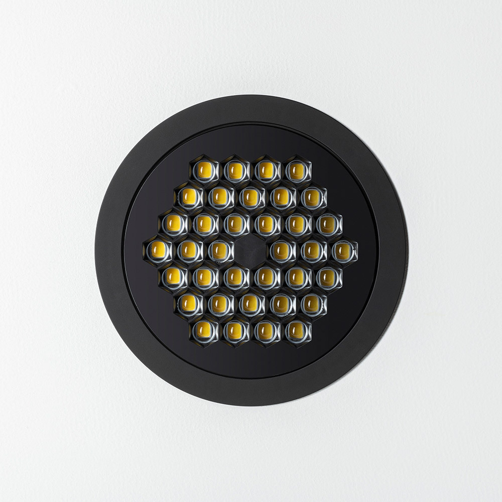 Front detail of Artemide’s Helgoland optical module, featuring a honeycomb structure with integrated LEDs in a black circular frame on a white background.