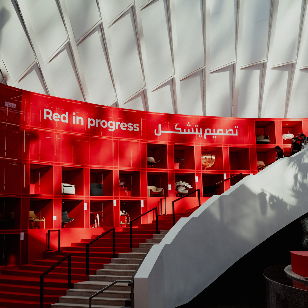 Photo of the installation for Salone del Mobile.Milano in Riyadh: a red cell-like structure displaying the products, accompanied by a red staircase that follows its profile.