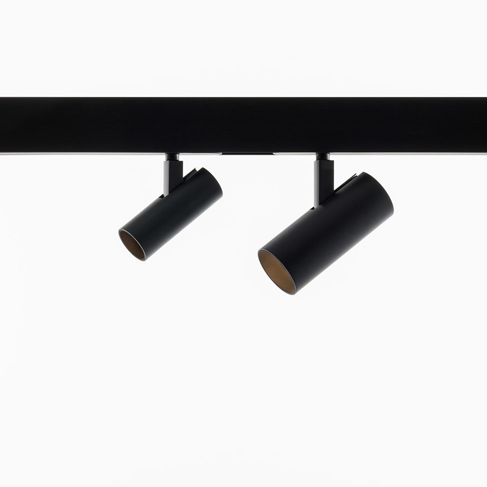 Two black cylindrical Vector LED spotlights on a track, adjustable for directional light.