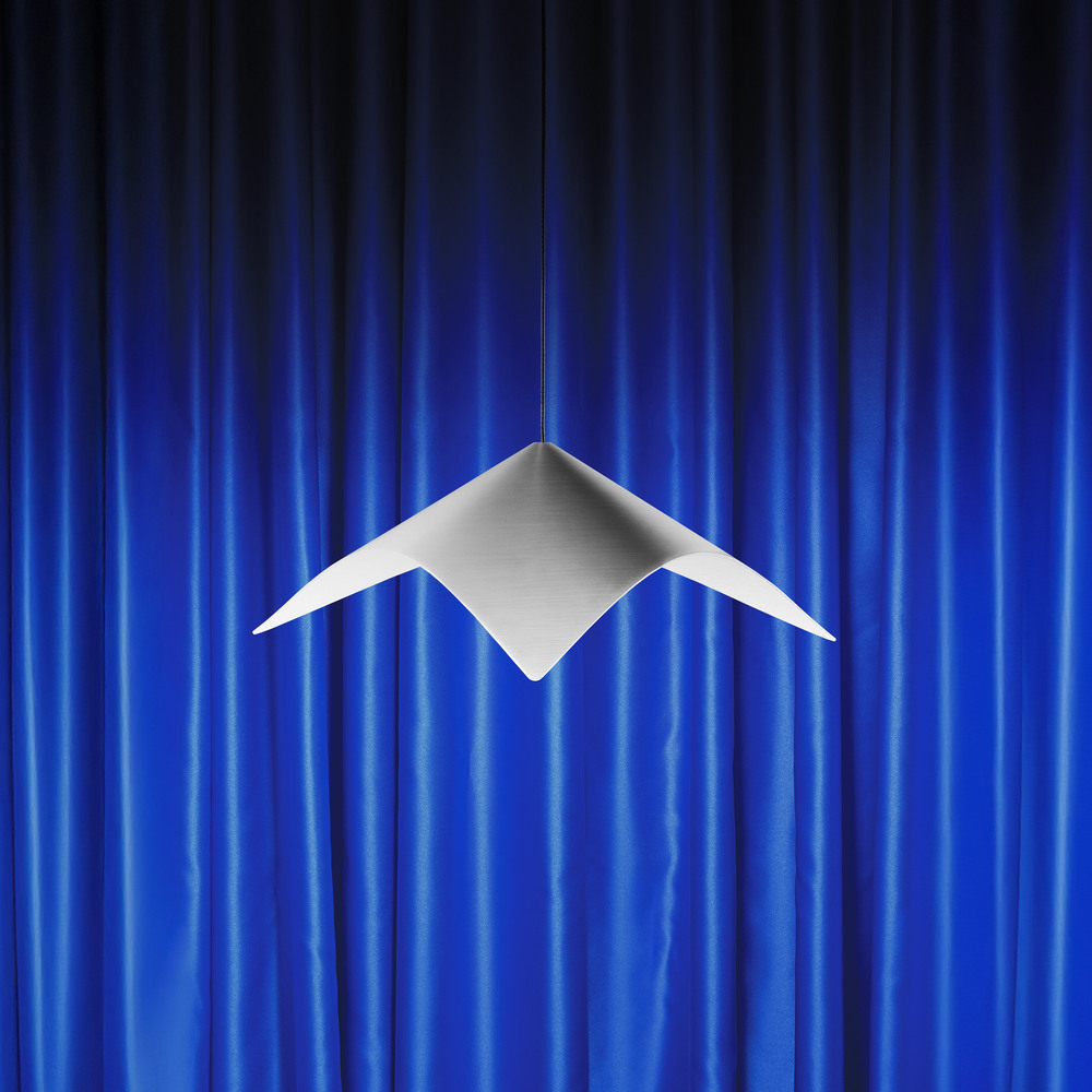 Iperbole pendant lamp in front of blue theater curtains.