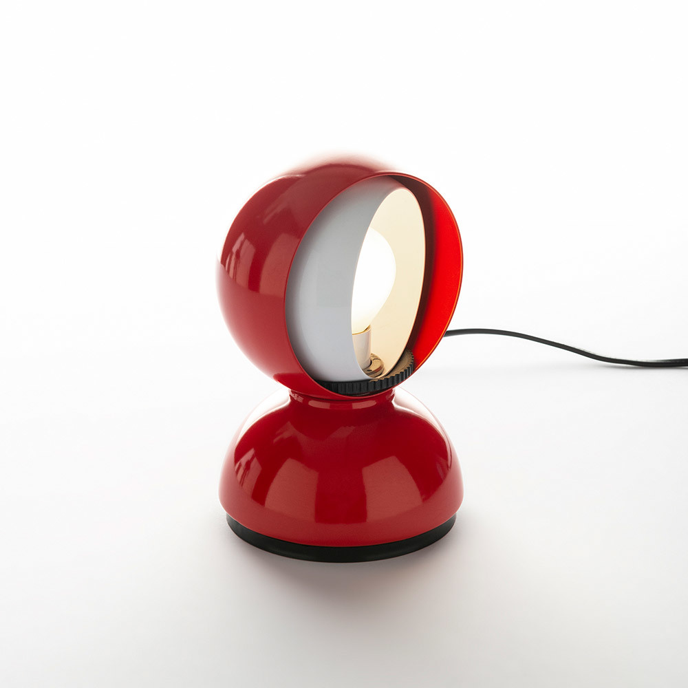 Lampe de table Artemide Eclisse en rouge, avec abat-jour sphérique pivotant révélant un diffuseur intérieur, sur socle en dôme.