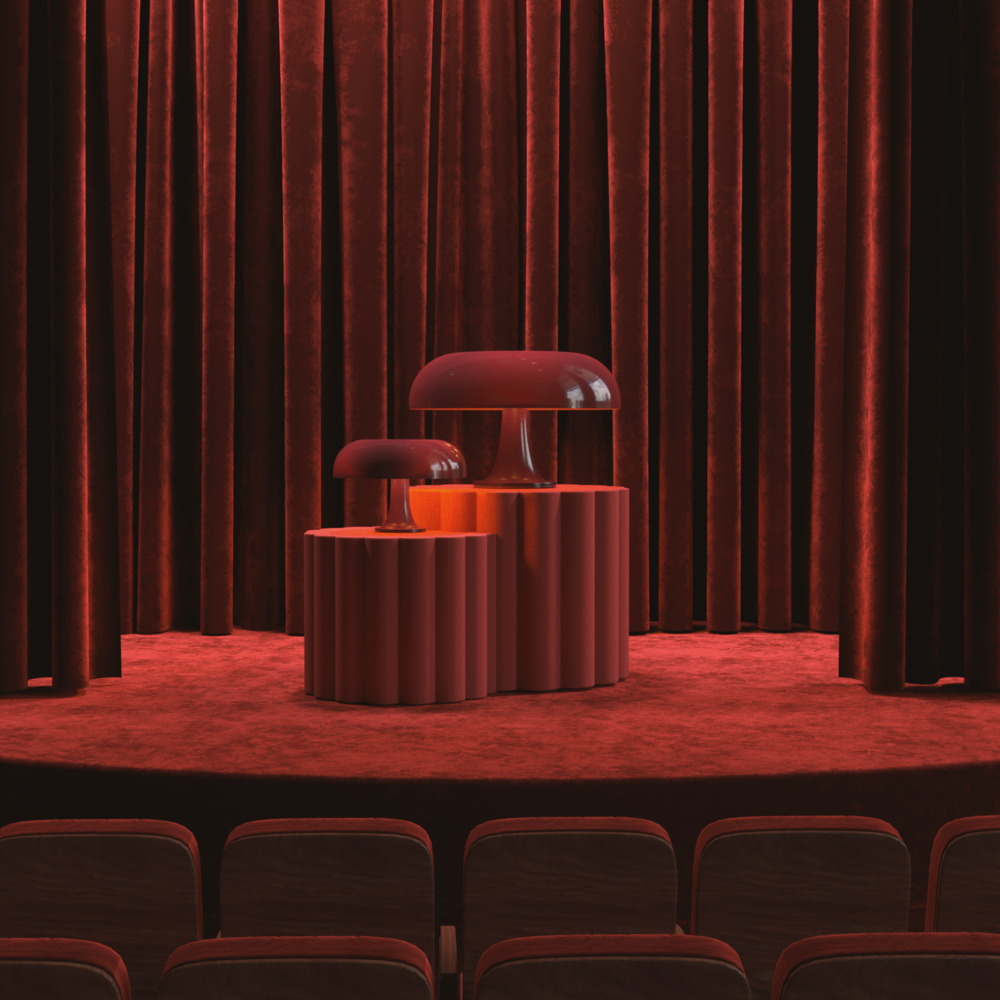 Deux lampes de table en forme de champignon bordeaux exposées sur un piédestal cylindrique cannelé sur une scène de théâtre rouge avec rideaux en velours