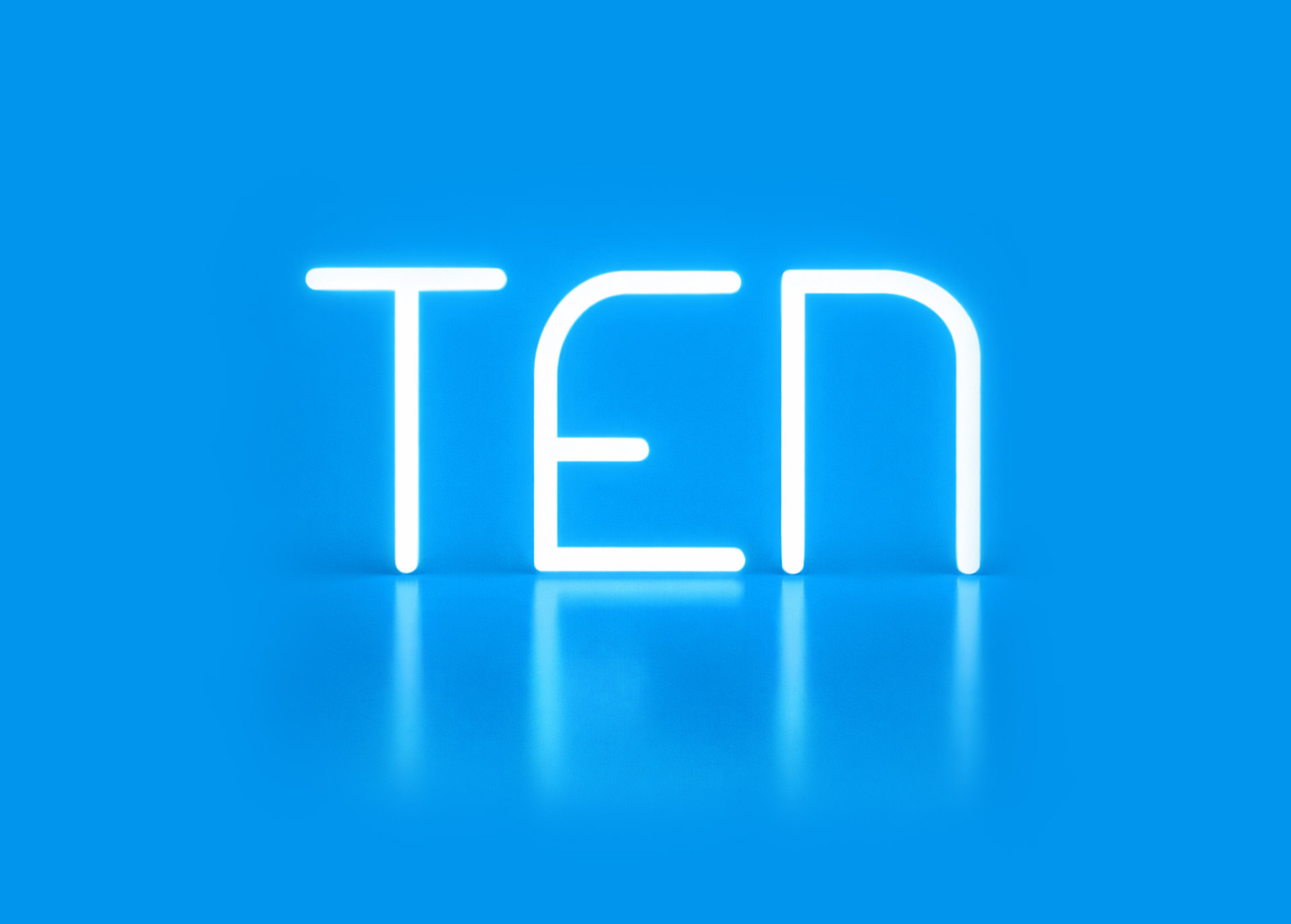 Illuminated “TEN” lettering created with Alphabet of Light, set against a blue background with reflection on the glossy surface.