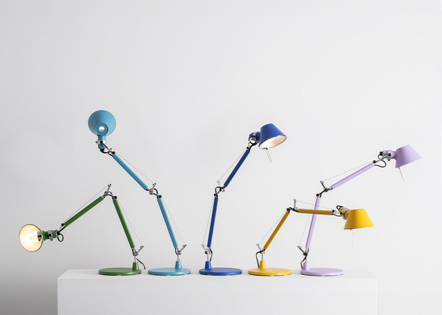 Series of five Tolomeo table lamps in various colors, with articulated aluminum arms, arranged on a white surface against a light background.
