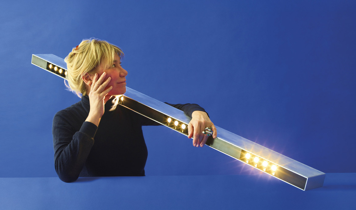 Portrait of Carlotta de Bevilacqua against a blue background, photographed by Pierpaolo Ferrari.