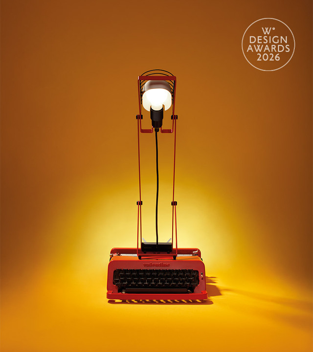 Sintesi rossa su sfondo giallo, fotografata da Pierpaolo Ferrari, con macchina da scrivere Valentine rossa e logo del Wallpaper Design Award.