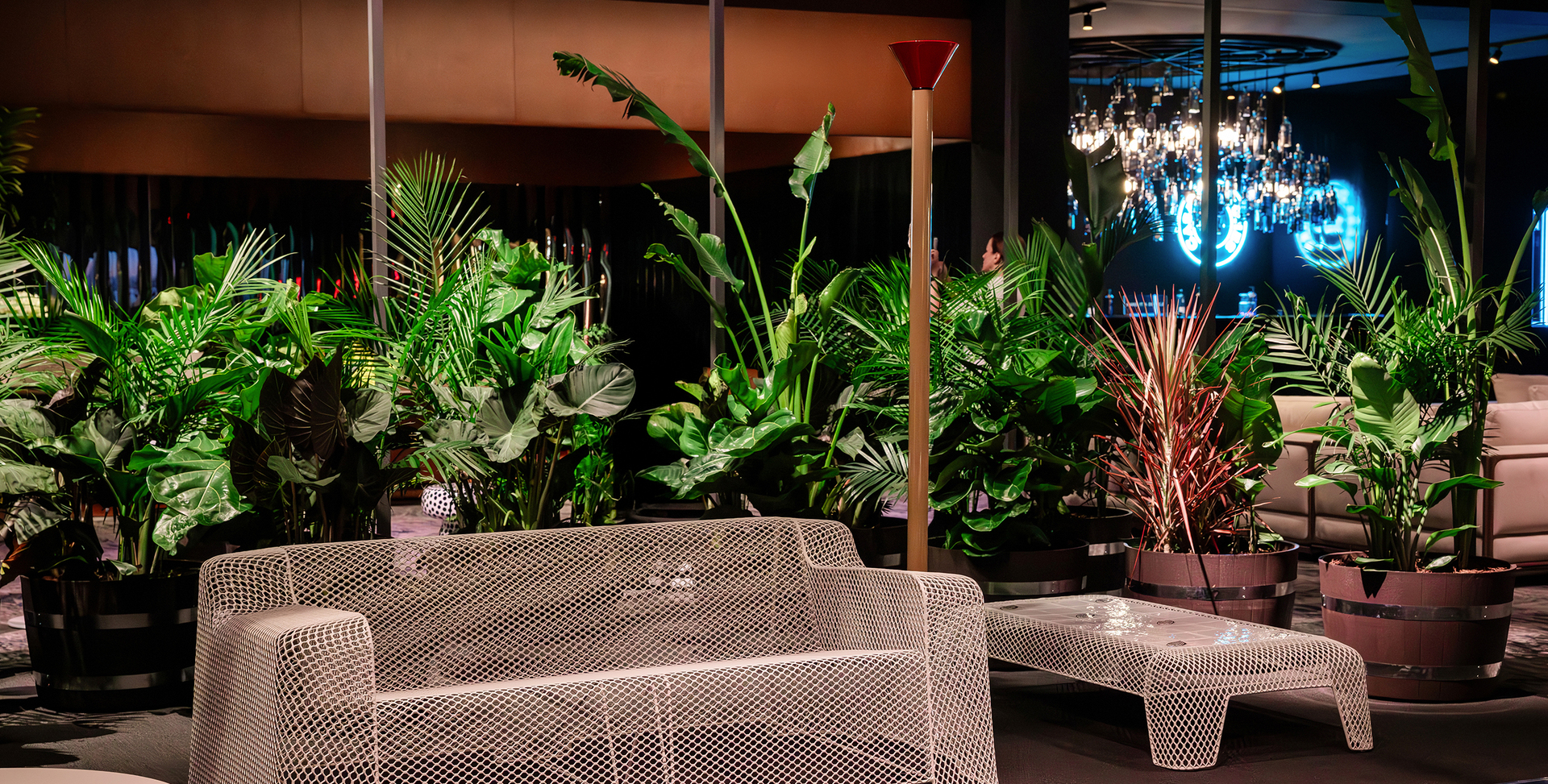 Installation view of the Salone del Mobile.Milano Collectors Lounge at Art Basel Miami Beach, featuring a living area with sofa, side table and Callimaco lamp by Artemide; plants in the background frame the space.