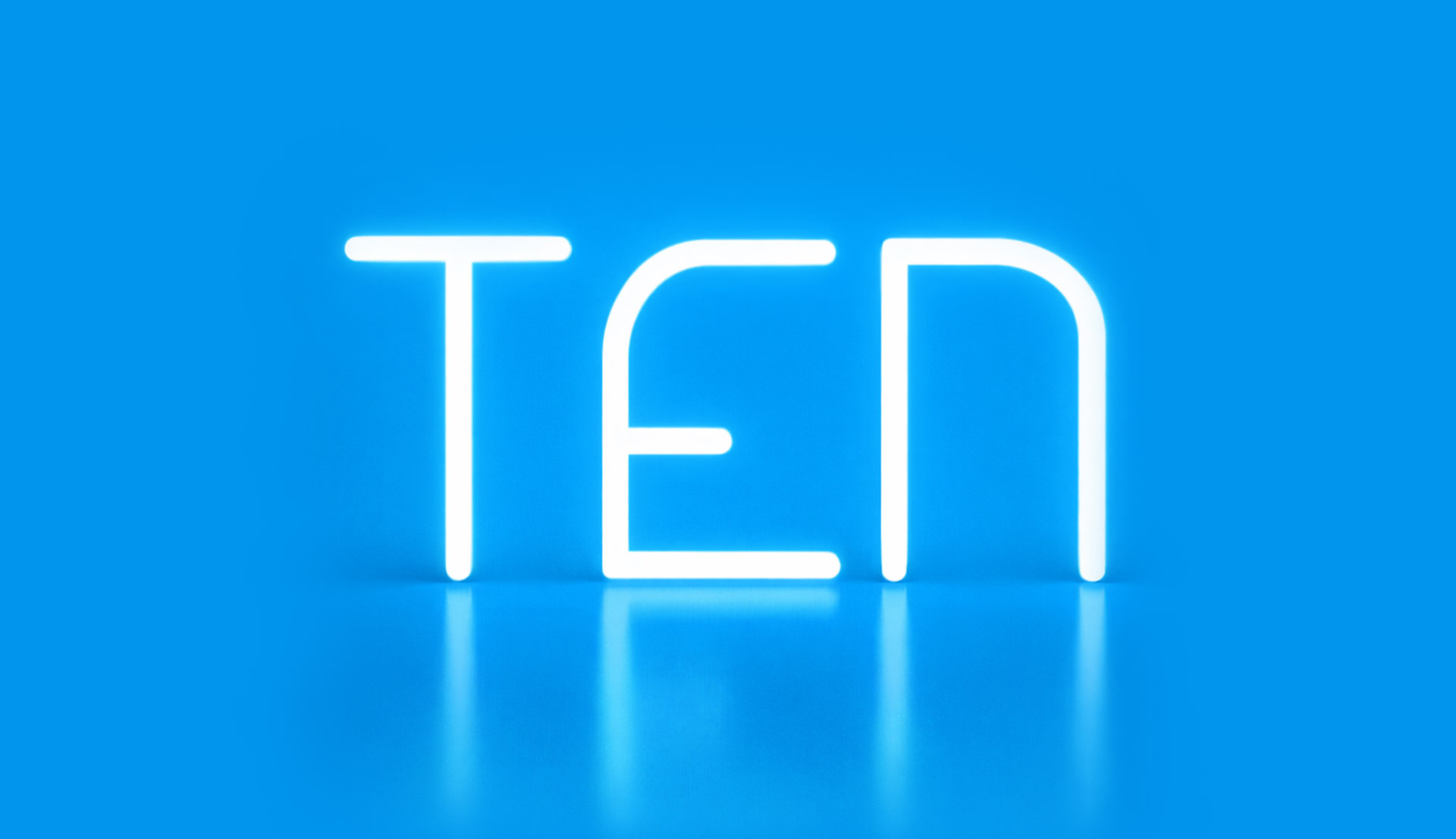 Illuminated “TEN” lettering created with Alphabet of Light, set against a blue background with reflection on the glossy surface.