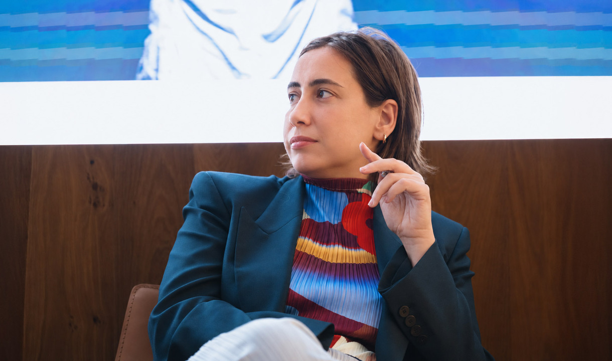 Carolina Gismondi de Bevilacqua seduta durante un talk, mentre guarda verso un altro relatore.