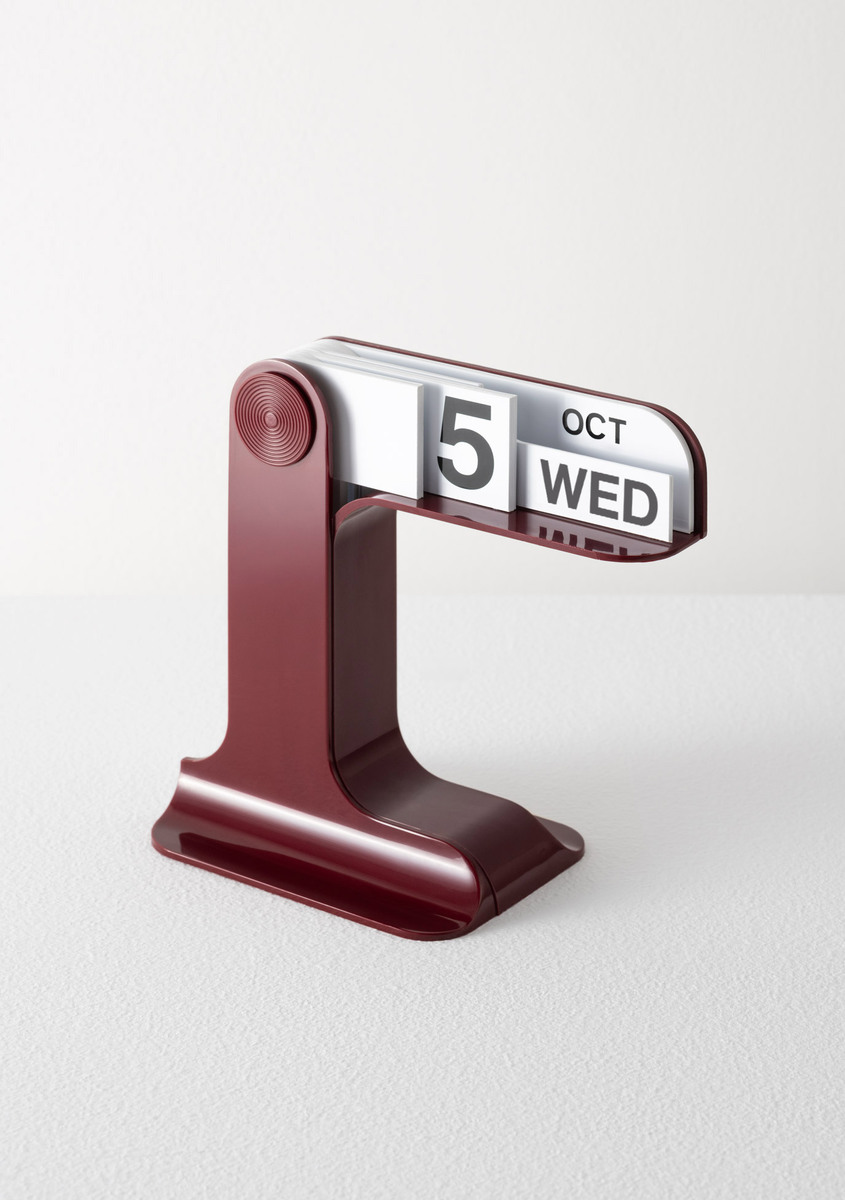 Timor desk calendar in a bordeaux finish showing the date and day of the week, against a white background.