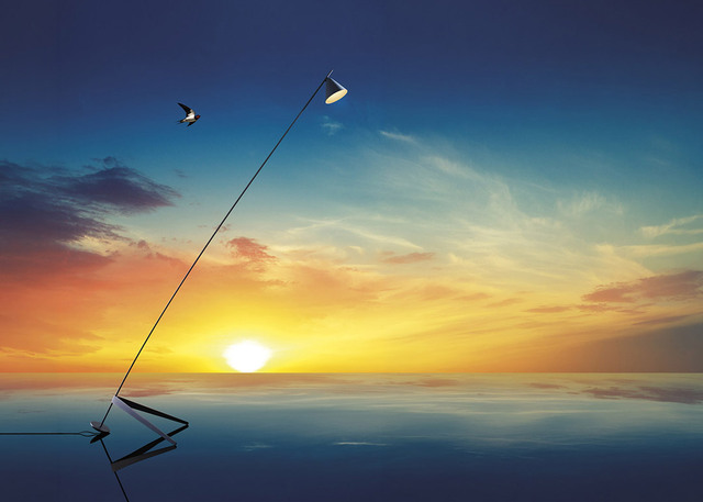 Lámpara de pie Artemide con delgado vástago diagonal y cabezal orientable, reflejada en el agua ante un vibrante cielo al atardecer.