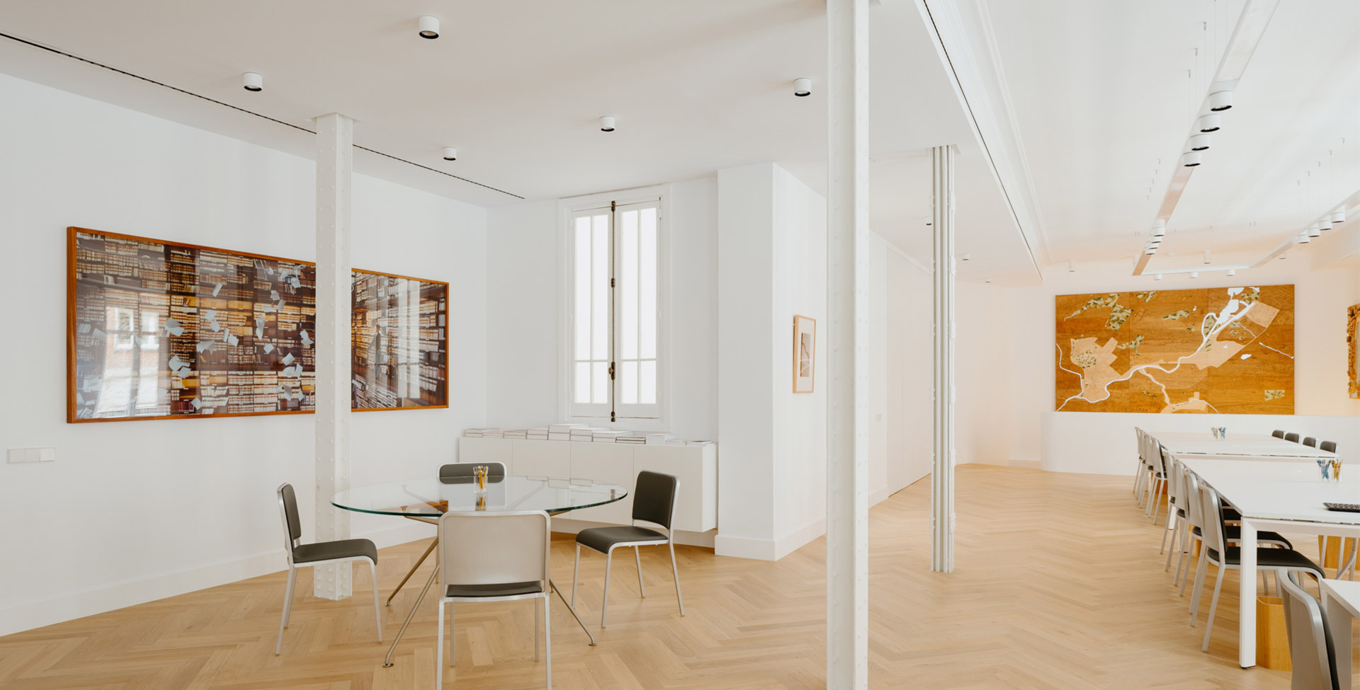 Space of the Norman Foster Institute with tables and chairs, illuminated by Hoy System and Hoy Spot.