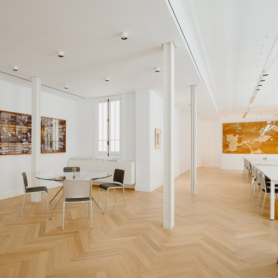 Space of the Norman Foster Institute with tables and chairs, illuminated by Hoy System and Hoy Spot.