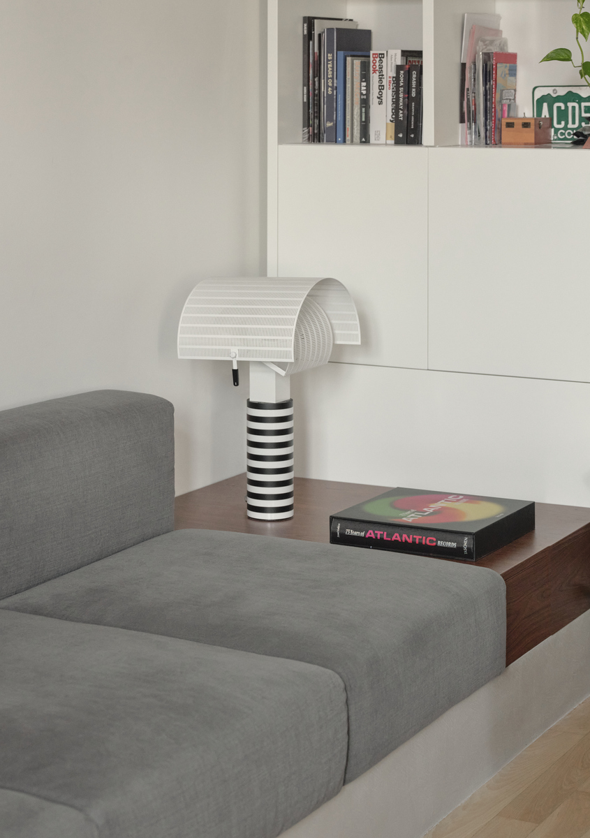 Close-up of Artemide’s Shogun table lamp in the living area, placed on a wooden surface beside the sofa.